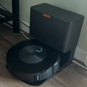 Black iRobot Roomba Combo j5 Plus vacuum and its docking station on a hardwood floor. - Roomba Combo j5 Plus user experiences​

