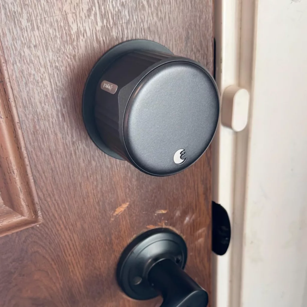 Yale August Wi-Fi Smart Lock installed on the interior side of a front door, showing its sleek design and seamless integration with existing deadbolts.